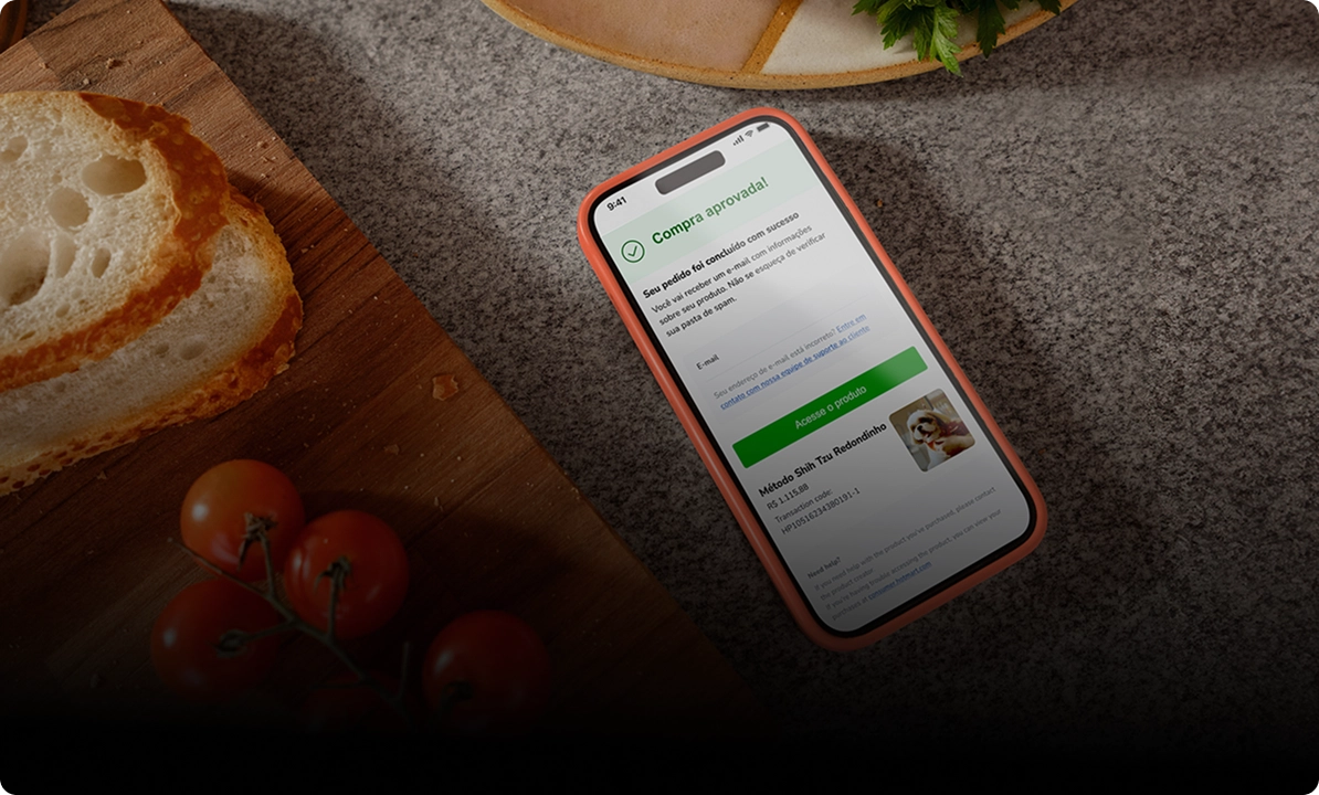 Foto de um smartphone exibindo uma tela de pagamento, com alimentos à esquerda, incluindo fatias de pão e tomates, e uma superfície de pedra ao fundo